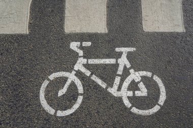 Gri asfalta beyaz boyayla boyanmış bir bisikletin fotoğrafı.