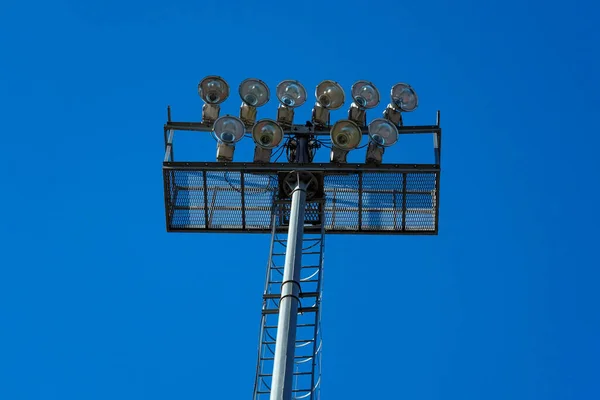 Zdjęcie Masztu Oświetlenia Boisku Piłkarskim Przeciwko Błękitnemu Bezchmurnemu Niebu — Zdjęcie stockowe