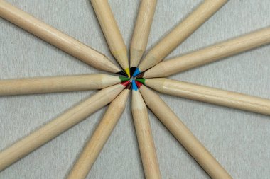 Sıraya dizilmiş renkli kalemler daire oluşturuyor. Aynı renkte renkli kalemler.