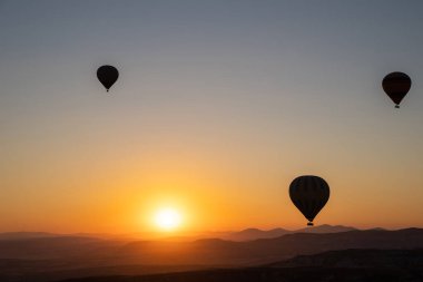 Yazın gökyüzünde renkli sıcak hava balonları olan kırsal dağların güzel doğa manzarası. Seyahat panorama arka planı.