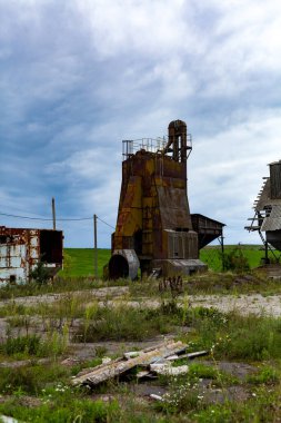 Şehrin dışındaki bir arazide terk edilmiş paslı bir metal binanın dikey fotoğrafı..