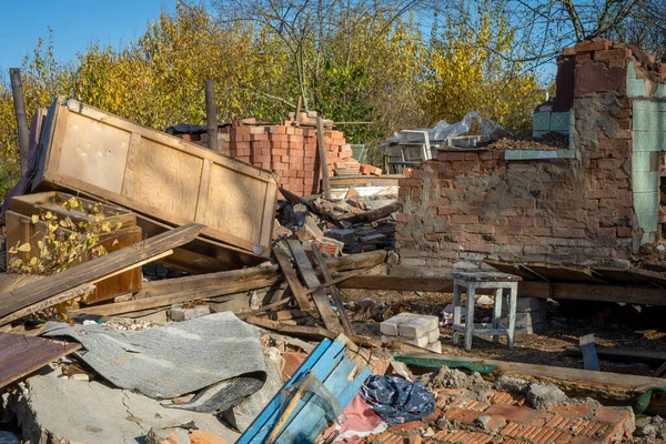ゴミやゴミ ゴミなどを背景にした古い赤レンガ造りの家の廃墟の写真 — ストック写真