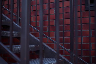 Kırmızı tuğladan bir arka planda metal bir merdiven fotoğrafı..