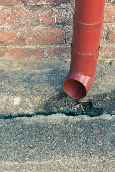 Vertikalt Foto Röd Metallrör Bakgrunden Tegelvägg Ett Hus Gata Staden — Stockfoto