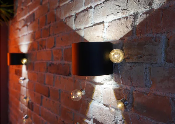 Güzel, gizemli bir lambası ve duvarda yayılmış ışığı olan kırmızı tuğladan bir duvar..