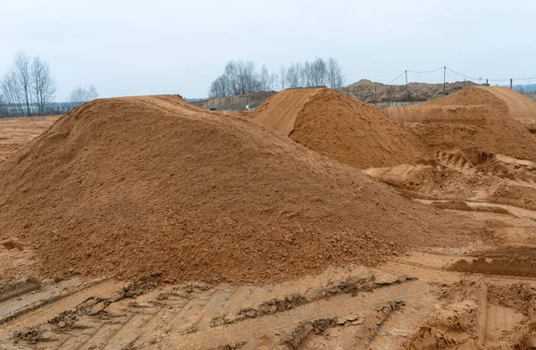 Şehrin dışındaki bir caddedeki inşaat alanında kumlu dağların fotoğrafı..