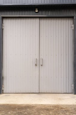 Gri metal bir kapının dikey fotoğrafı. Araba için garaja giriş..