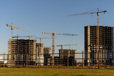 Şehirdeki çok katlı bina ve vinçlerin inşaat alanının fotoğrafı.