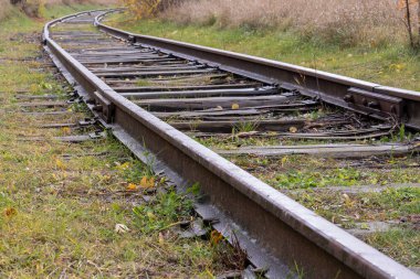 Ahşap tren yolu ve yeşil çimlerin fotoğrafı. Tren ve ulaşım kavramı.