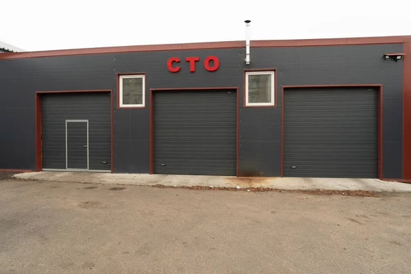 Arabalar için garajları olan gri bir binanın fotoğrafı. Servis İstasyonu.