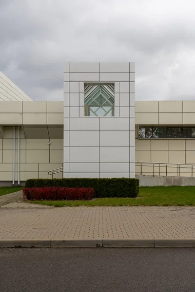 Şehirde ışıklı duvarları ve pencereleri olan bir binanın dikey fotoğrafı. Kasaba ve şehir kavramı.