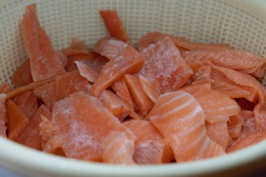 İşlemden sonra bir kasede çiğ kırmızı balık parçaları.. 