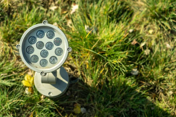 街の公園の通りにある緑の芝生の上に電球の小さな提灯の写真 光の概念 — ストック写真