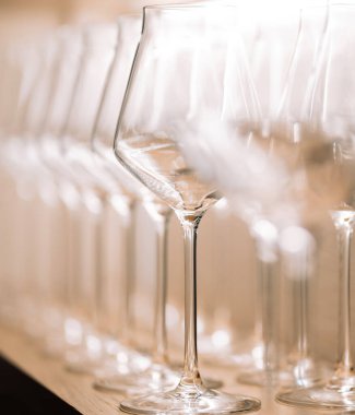 Aynı boyutta temiz şarap bardakları dolapta sergilenir. Olağandışı bir bakış açısı, bulanık bir arka plan. Bir bardağa dikkat edin.