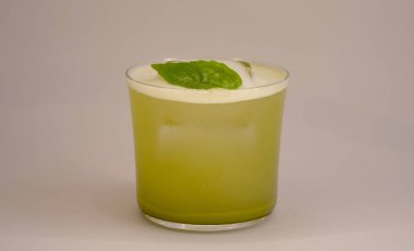 Buzlu, naneli ve köpüklü cam bardakta yeşil kokteyl.