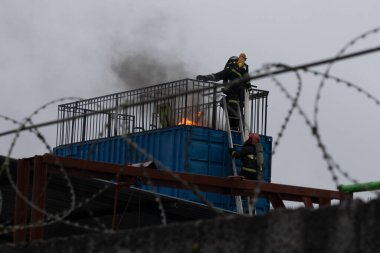 İtfaiyecilerden oluşan bir ekibin fotoğrafı yangını cesurca söndürüyor.