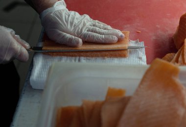 Şefin yakın çekim elleri kırmızı balığı kesti..