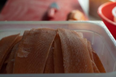 Mutfaktaki bir restoran masasında plastik bir kutuda kırmızı balık filetosu.. 