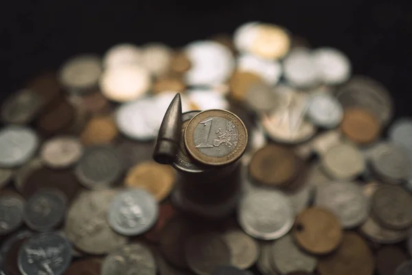 Tüfek fişeği madeni para yığınının üzerinde duruyor..