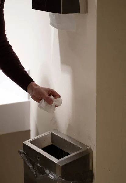 一个男人在厕所洗手后把纸扔进垃圾堆的照片 — 图库照片