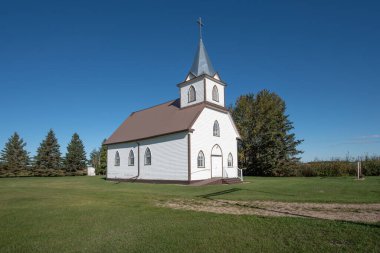 Saskatchewan kırsalında İskandinav tarzı bir Lüteriyen kilisesi. Kilise, kahverengi çerçeveli kemerli camlı beyaz ahşap kaplamalı. Üzerinde haç olan bir çan kulesi var..