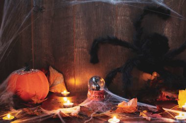 Cadılar Bayramı dekoru, ahşap bir duvara karşı örümcek ağları ve mumlarla