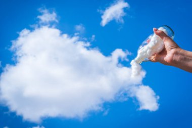 Bulutlar berrak bir cam şişeden çıkar - kutunun dışını düşün