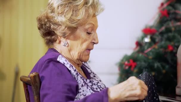 Yılbaşı geçmişi olan yaşlı bir kadın, antika dikiş makinesiyle dikiş dikiyor. — Stok video