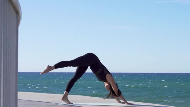 Krásná mladá žena cvičí jógu na pláži — Stock video