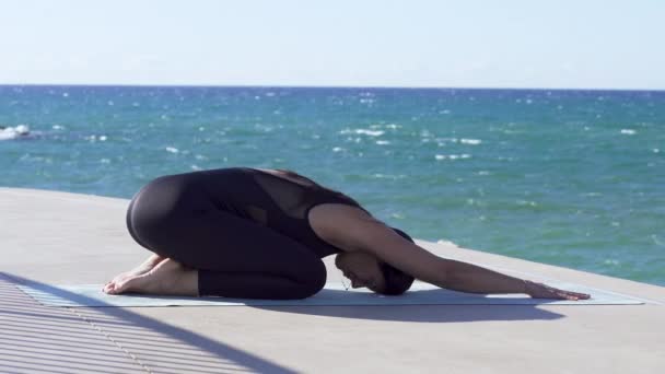 Bella giovane donna che pratica yoga sulla spiaggia — Video Stock