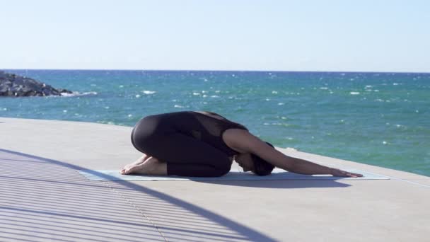 해변에서 요가 연습 하는 아름 다운 젊은 여자 — 비디오