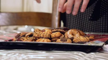  Kadın masadaki tepsiden tipik bir Noel kurabiyesi alıyor.