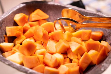  Papaya bir kasede ve papaya parçalarıyla süslenmiş.