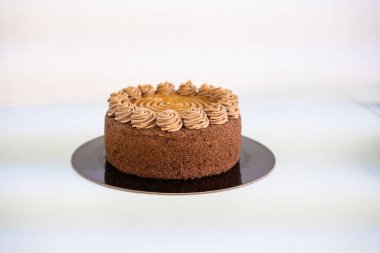  Lezzetli çikolata ve siyah tabakta karamel kek, beyaz arka plan..