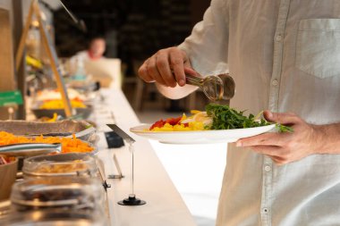  Erkekler otelin büfesinde yemek yiyor..