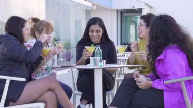  Bir grup arkadaş kokteyl içip öğleden sonra kahkaha atıyorlar..