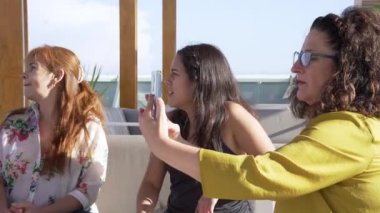  Bir grup arkadaş kokteyl içiyor ve cep telefonlarıyla iletişim kuruyor..