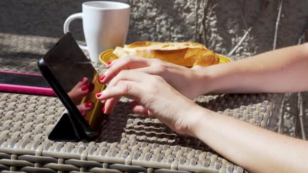 Mujer joven desayunando mientras telemuta. — Vídeos de Stock