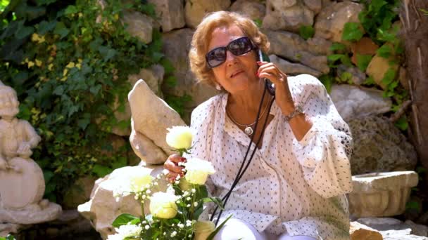 Beautiful elderly woman excited with her gift of white roses. — Stock Video