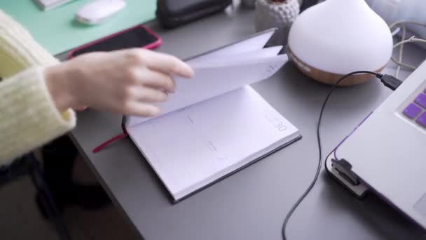 O tânără care stă la birou, deschide un jurnal de 2021 de ani. — Videoclip de stoc