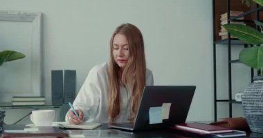 Yaratıcı uğraş. Bilgisayarla çalışan başarılı sarışın iş kadını modern ışıklı ofis masasında düşünüyor..