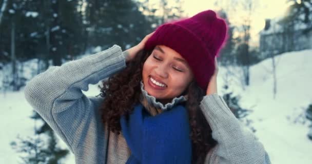 Humor de inverno. Retrato de feliz jovem bela mista mulher de raça sorrindo para a câmera em neve floresta câmera lenta. — Vídeo de Stock