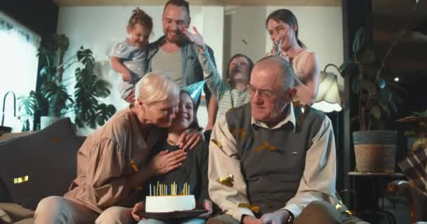 Familia multigeneracional juntos. Feliz niña adolescente sonriente celebrando cumpleaños abrazando a los abuelos en el sofá de casa. — Vídeos de Stock