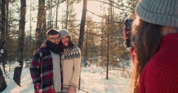 Щаслива красива романтична пара посміхається позує на фотосесію разом у чудовому сніжному зимовому лісі повільний рух . — стокове відео