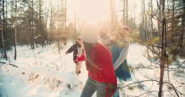 Mutlu, çoklu etnik çeşitlilikte gülümseyen arkadaşlar hafta sonları yavaş çekimde karlı kış orman yürüyüş yolu boyunca yürürler..