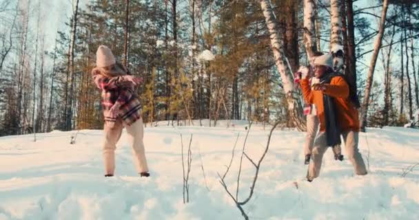 Ενθουσιασμένη διασκέδαση ευτυχισμένη πολυεθνική φίλους απολαμβάνουν διακοπές χιονοπόλεμο με λευκό σκυλί σε ηλιόλουστο δάσος χειμώνα αργή κίνηση. — Αρχείο Βίντεο