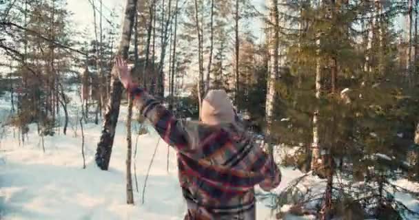 Visão traseira atmosférica câmera lenta, amigos felizes animados correm através da floresta fria de inverno nevado na caminhada de férias de Ano Novo. — Vídeo de Stock