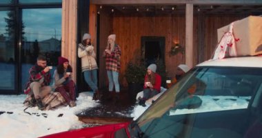 Yeni yıl tatili. Bir grup mutlu çok ırklı arkadaş, kışlık terasta sıcak çay içerken ağır çekimde kırmızı araba kullanıyorlar..