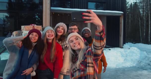 Grupo de amigos multiétnicos felices sonríen tomando fotos selfie en el chalet de Navidad nevado casa terraza cámara lenta. — Vídeos de Stock