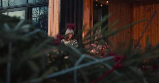 Film zpomalení, šťastný multietnické mladé přátele úsměv těší teplé nápoje na útulné zimní dovolená dům terasa. — Stock video